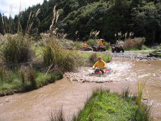 Adventure rider assessing and crossing a muddy river